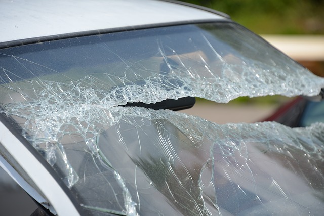 A severely cracked and shattered windshield in Minnesota. The glass has extensive damage with large cracks spreading across the surface, and some sections are completely broken, creating jagged edges